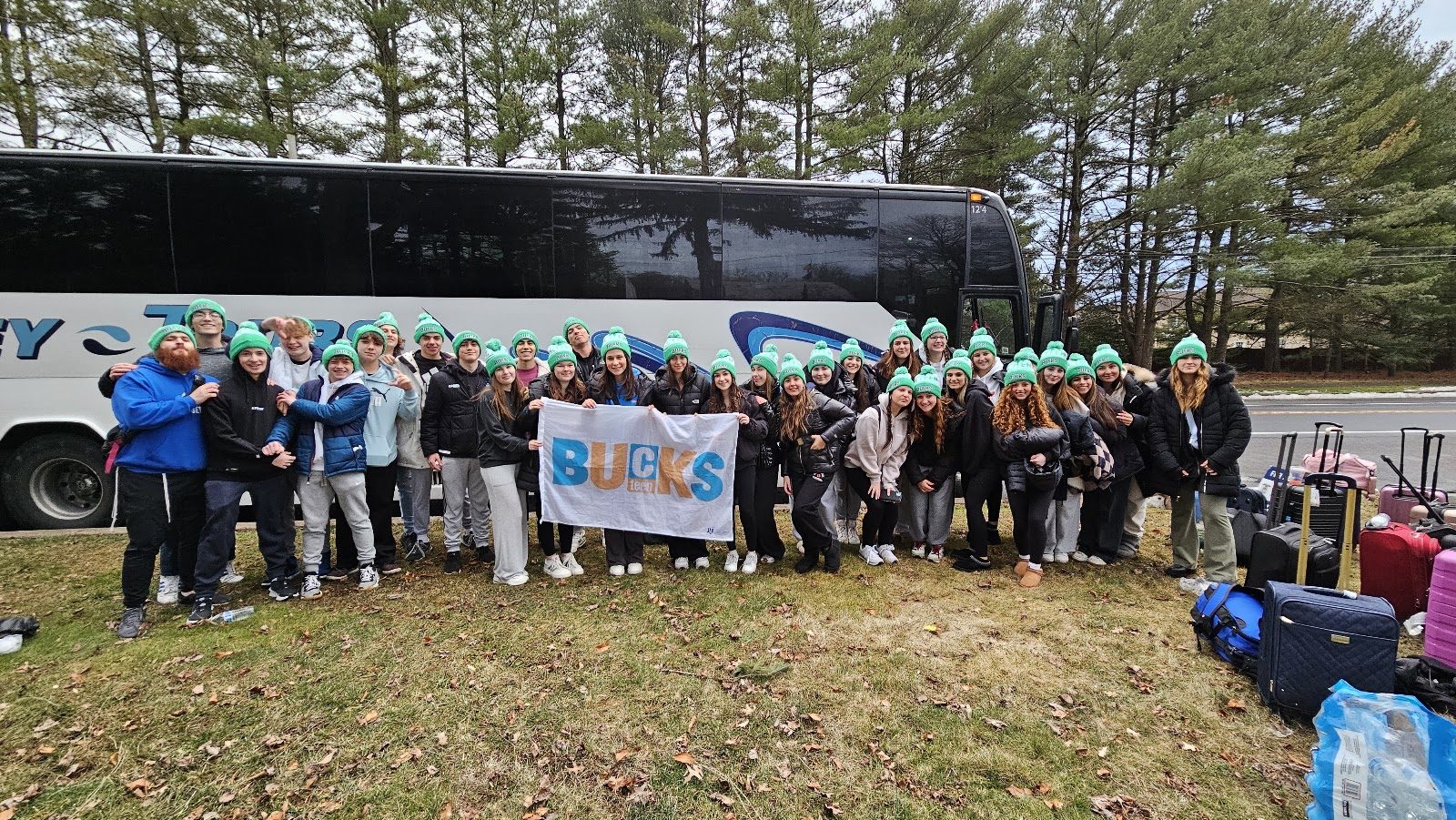 CTeen Bucks County teens holding the Bucks banner beside the bus before heading out on a trip
